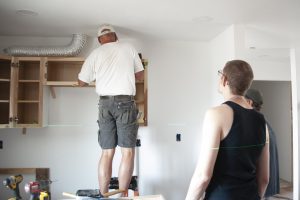 Kelcey Leaseburg and Bob Behal Working on Kitchen Cabinets at the Build Site
