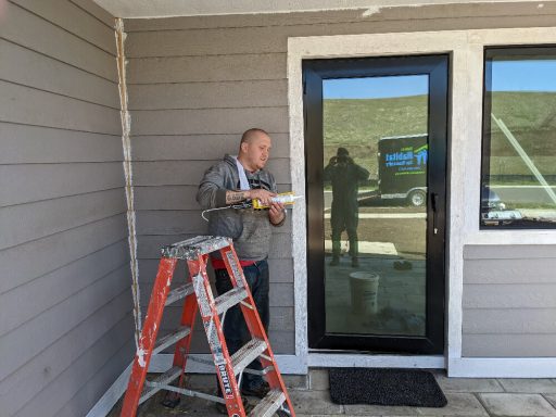 One of PHFH's volunteers, Kyle, caulking windows at a build site.